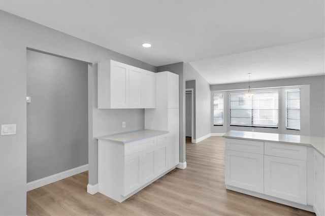 5925 Seaside Dr, New Port Richey, FL 34652 - kitchen featuring white cabinetry, light hardwood / wood-style floors, and hanging light fixtures