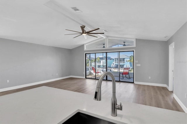 5925 Seaside Dr, New Port Richey, FL 34652 - unfurnished living room featuring vaulted ceiling with beams, hardwood / wood-style flooring, sink, and ceiling fan