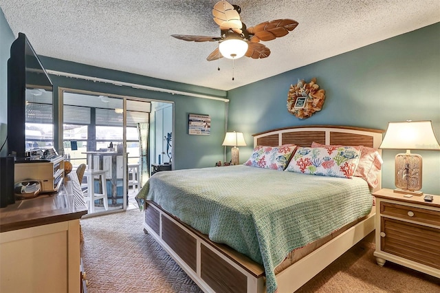 bedroom with ceiling fan, access to exterior, a textured ceiling, and dark colored carpet