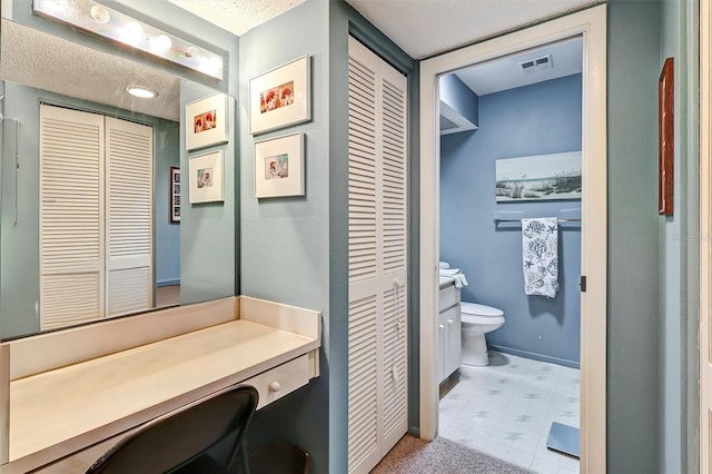 bathroom with vanity, a textured ceiling, and toilet