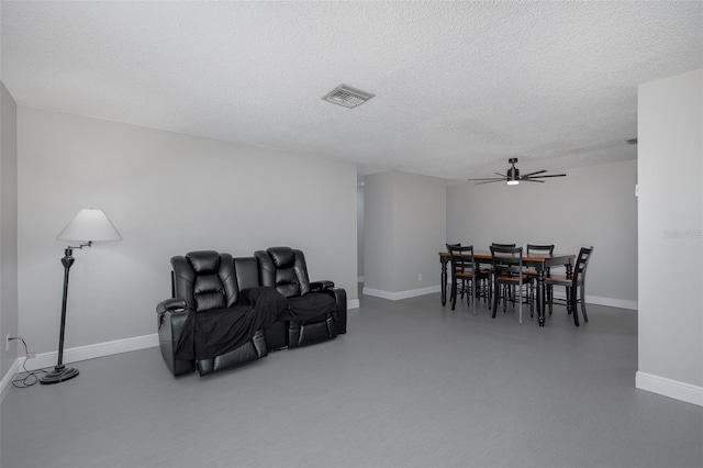 dining space with ceiling fan, a textured ceiling, and concrete floors