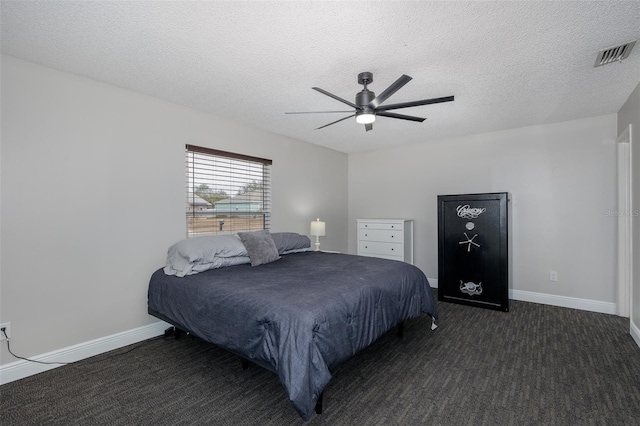 carpeted bedroom featuring ceiling fan and a textured ceiling