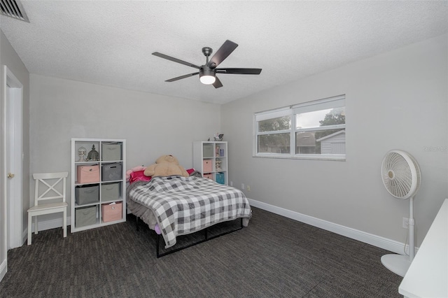 bedroom featuring dark colored carpet, ceiling fan, and a textured ceiling