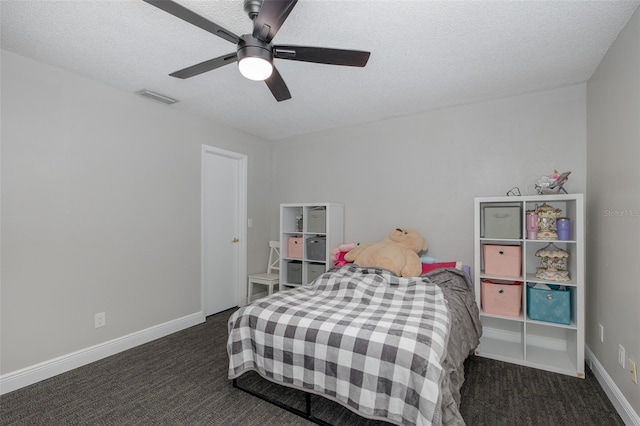 bedroom with dark colored carpet, ceiling fan, and a textured ceiling