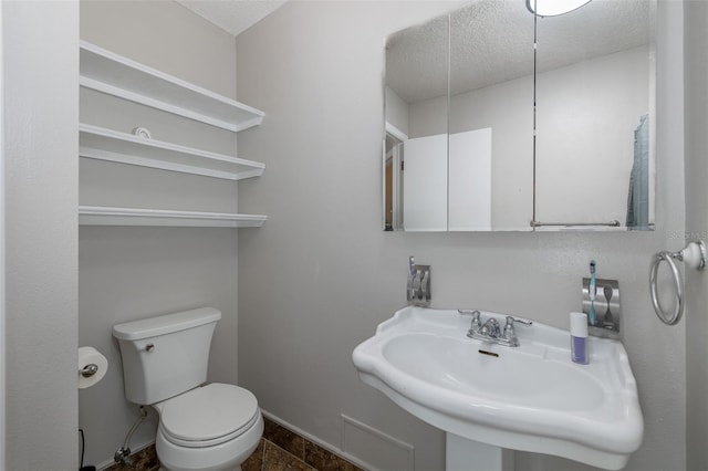 bathroom featuring sink, a textured ceiling, and toilet