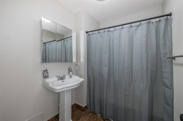 bathroom with a shower with curtain and a textured ceiling