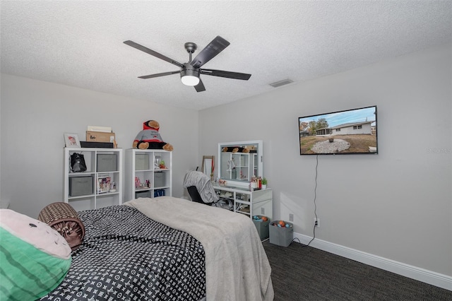 bedroom featuring ceiling fan, dark carpet, and a textured ceiling