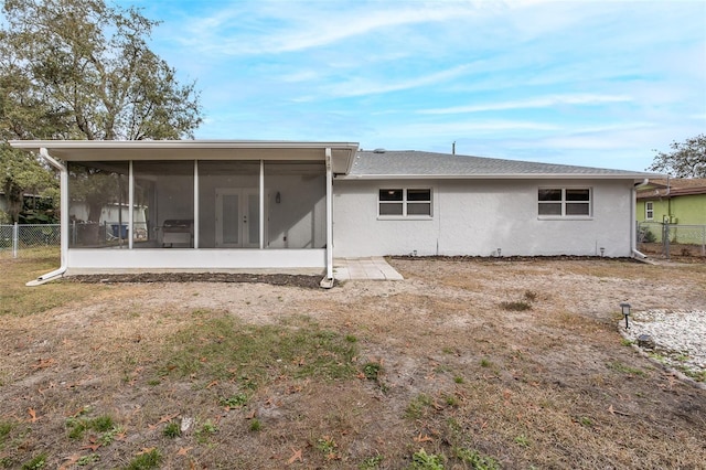 rear view of property featuring a sunroom