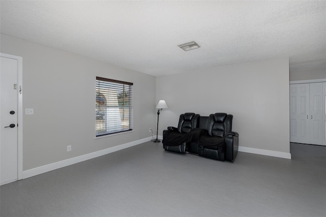 sitting room featuring a textured ceiling and concrete floors