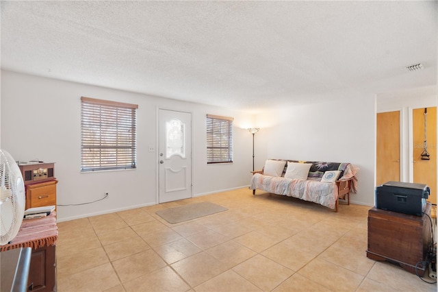 living room with plenty of natural light, a textured ceiling, and light tile patterned flooring