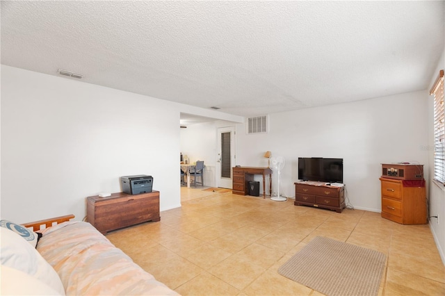 tiled living room featuring a textured ceiling