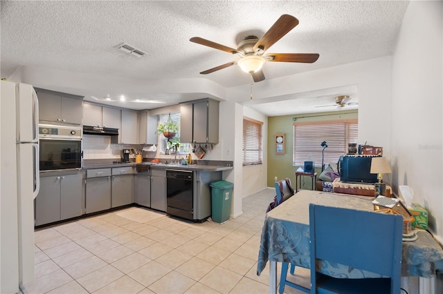 kitchen with dishwasher, gray cabinetry, light tile patterned flooring, stainless steel oven, and white fridge