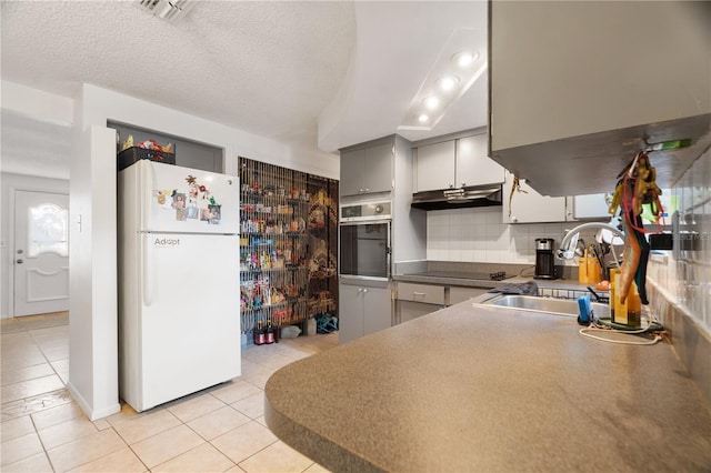 kitchen with sink, gray cabinetry, oven, white fridge, and black electric cooktop