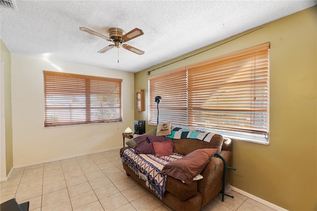 tiled living room featuring a textured ceiling and ceiling fan