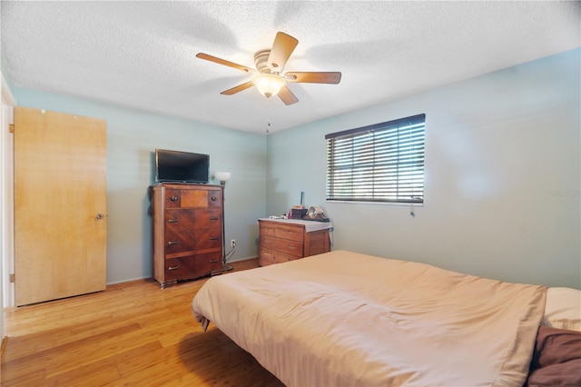 bedroom featuring ceiling fan, a textured ceiling, and light wood-type flooring