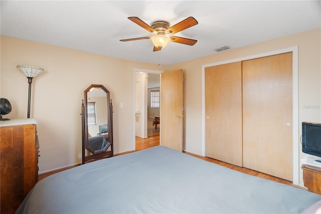 bedroom featuring light hardwood / wood-style floors, ceiling fan, and a closet