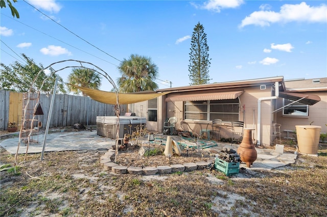 back of house with a patio area and a hot tub