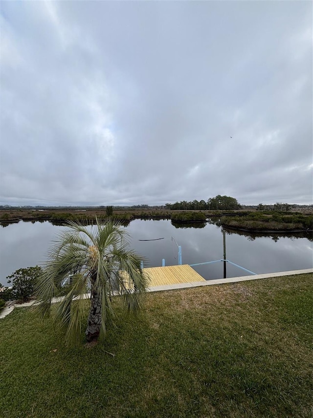 dock area with a water view and a yard