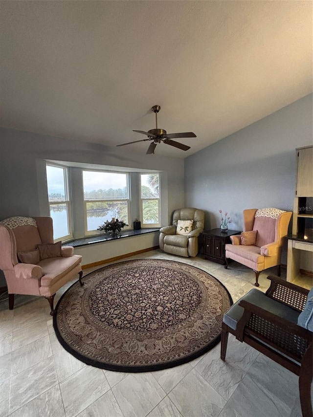 living room with a water view, ceiling fan, and lofted ceiling