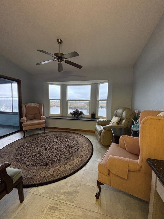 sitting room with a water view, lofted ceiling, and ceiling fan