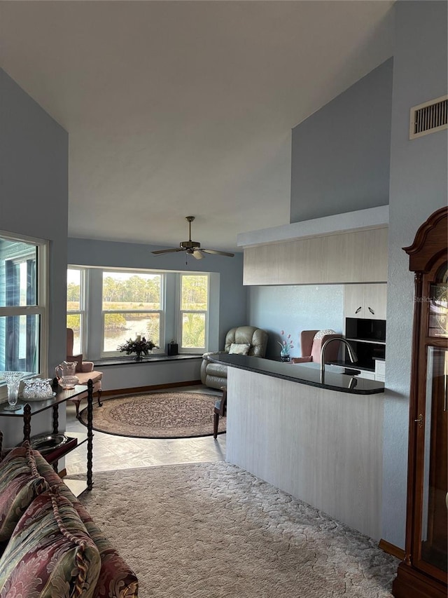 living room with ceiling fan, sink, and light carpet