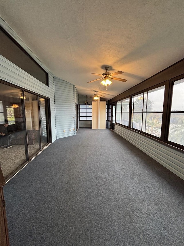 interior space with ceiling fan, a textured ceiling, and carpet