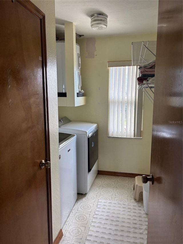 clothes washing area featuring cabinets and washing machine and dryer