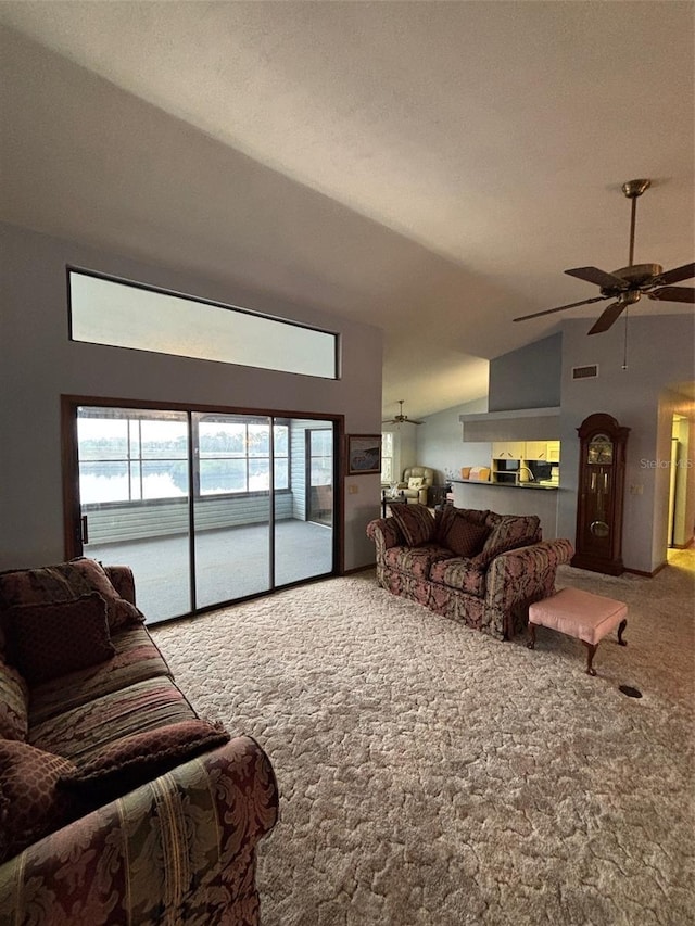 carpeted living room featuring a wealth of natural light, vaulted ceiling, and ceiling fan