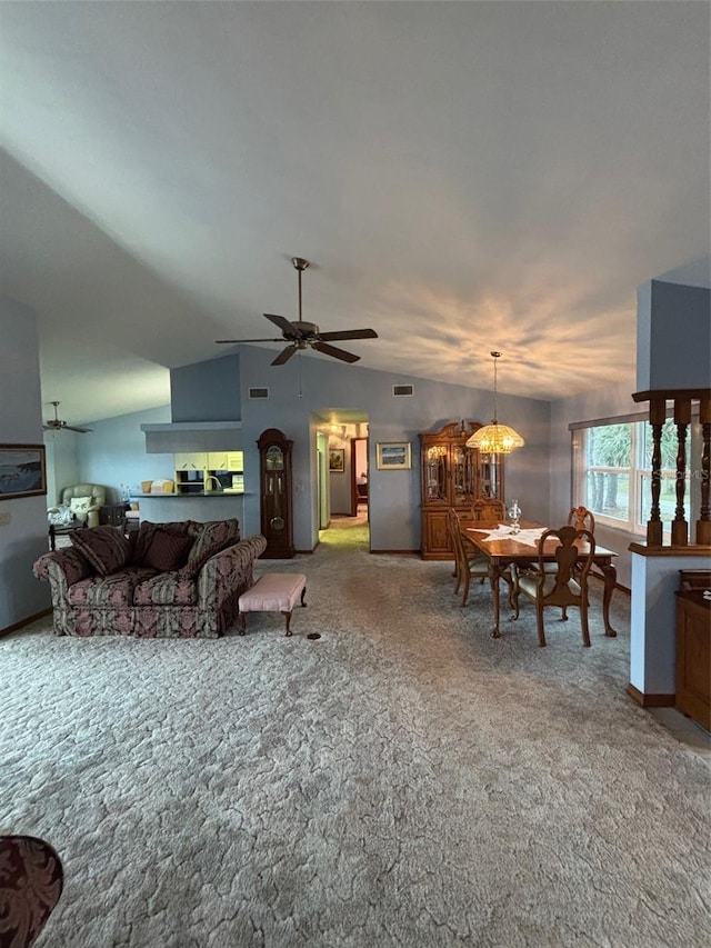 carpeted living room with ceiling fan and vaulted ceiling