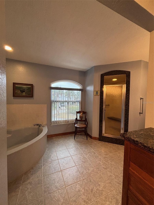 bathroom with tile patterned floors, vanity, separate shower and tub, and a textured ceiling