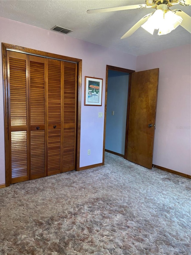 unfurnished bedroom featuring ceiling fan, carpet, a closet, and a textured ceiling