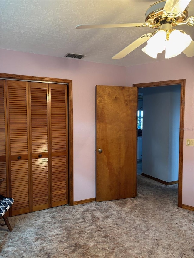 unfurnished bedroom featuring ceiling fan, carpet, a textured ceiling, and a closet