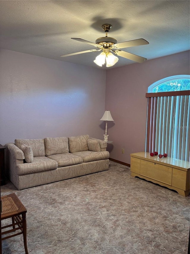 unfurnished living room featuring ceiling fan, carpet flooring, and a textured ceiling