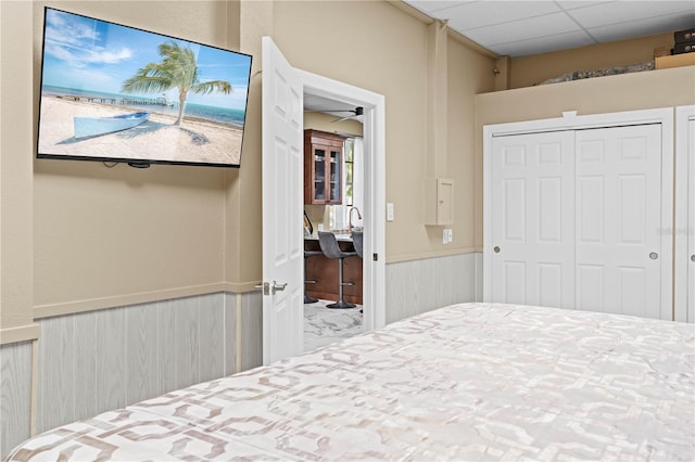 bedroom with a paneled ceiling and a closet