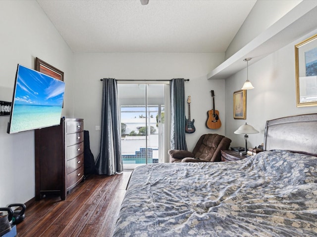 bedroom featuring access to outside, dark hardwood / wood-style floors, and a textured ceiling