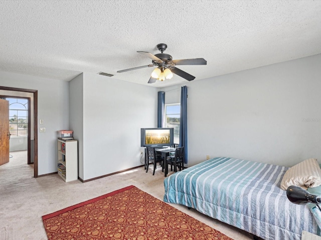 bedroom featuring light carpet, multiple windows, and a textured ceiling