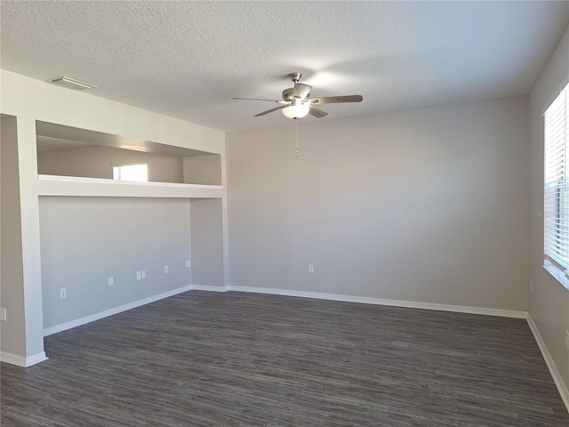 unfurnished room with dark hardwood / wood-style floors, a wealth of natural light, and a textured ceiling