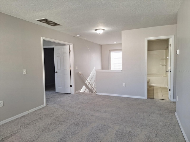 empty room featuring light carpet and a textured ceiling