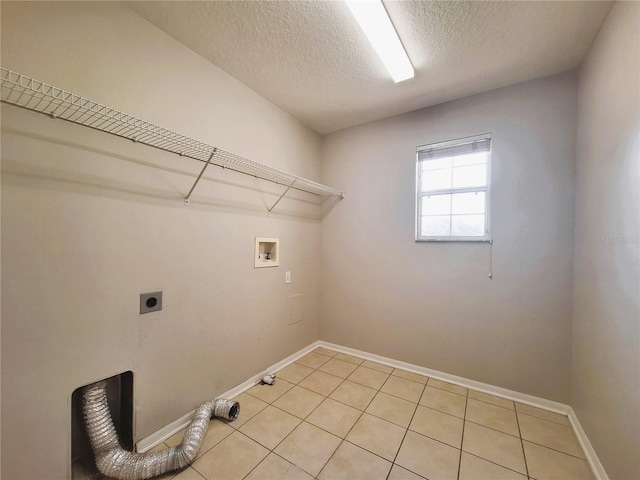 clothes washing area featuring hookup for a washing machine, electric dryer hookup, light tile patterned floors, and a textured ceiling