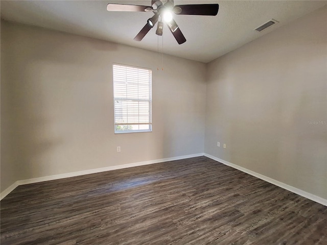 empty room with ceiling fan and dark hardwood / wood-style flooring