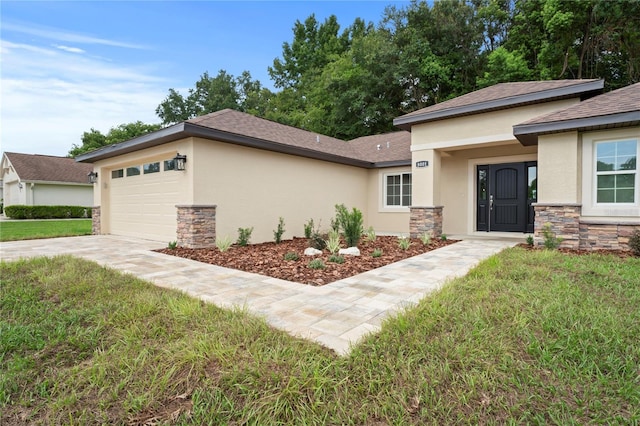 prairie-style home with a garage and a front yard