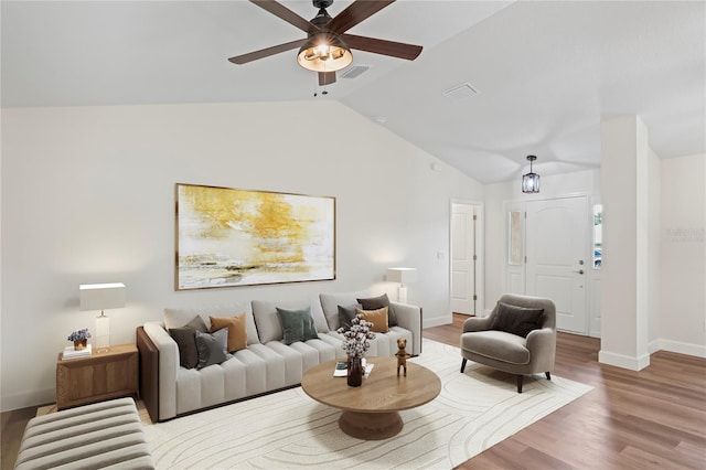 living room featuring ceiling fan, wood-type flooring, and vaulted ceiling