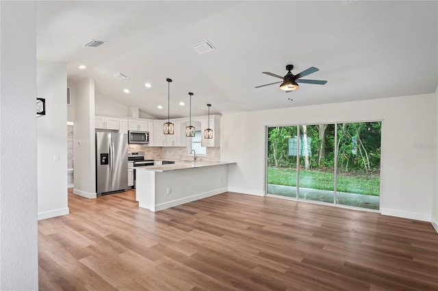 kitchen with appliances with stainless steel finishes, pendant lighting, white cabinetry, sink, and kitchen peninsula