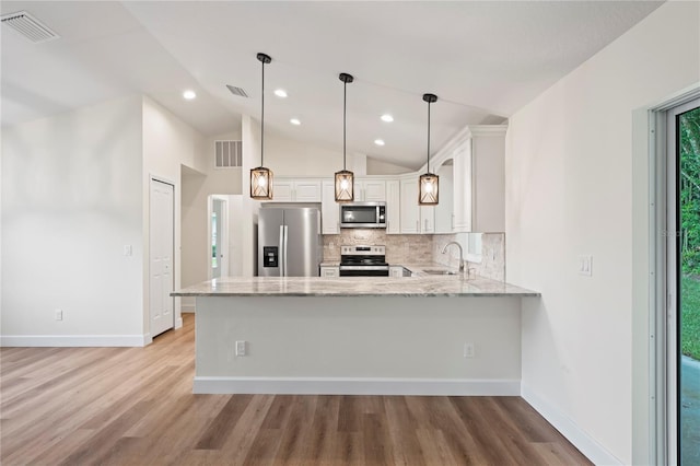 kitchen featuring appliances with stainless steel finishes, decorative light fixtures, white cabinets, backsplash, and kitchen peninsula