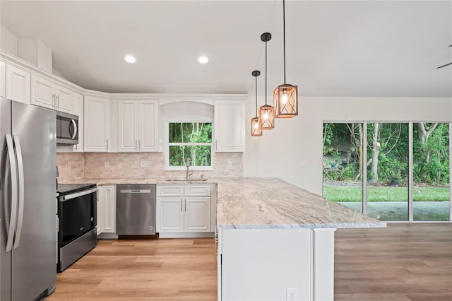 kitchen with sink, stainless steel appliances, kitchen peninsula, and white cabinets