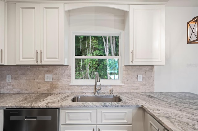 kitchen with dishwasher, sink, white cabinets, and light stone counters