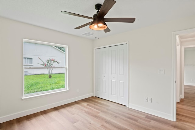 unfurnished bedroom featuring light hardwood / wood-style floors, a closet, and ceiling fan