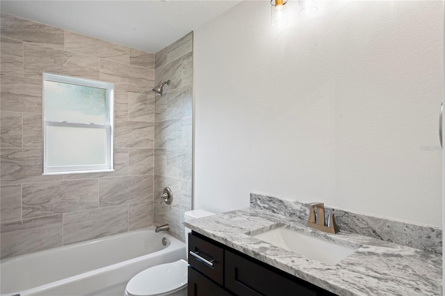 full bathroom featuring tiled shower / bath combo, vanity, and toilet