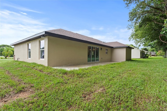 rear view of house featuring a yard and a patio area