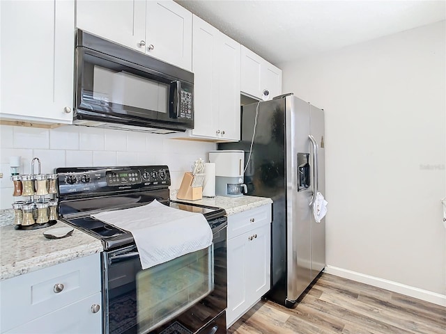 kitchen featuring tasteful backsplash, white cabinetry, black appliances, light hardwood / wood-style floors, and light stone counters